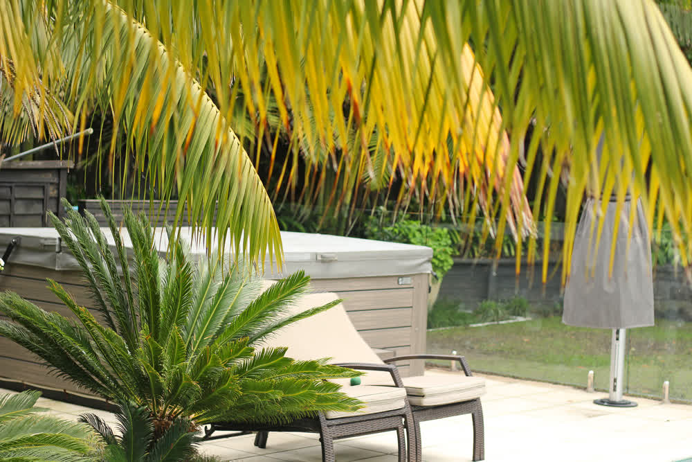 Tiled poolside entertainment area with spa and loungers